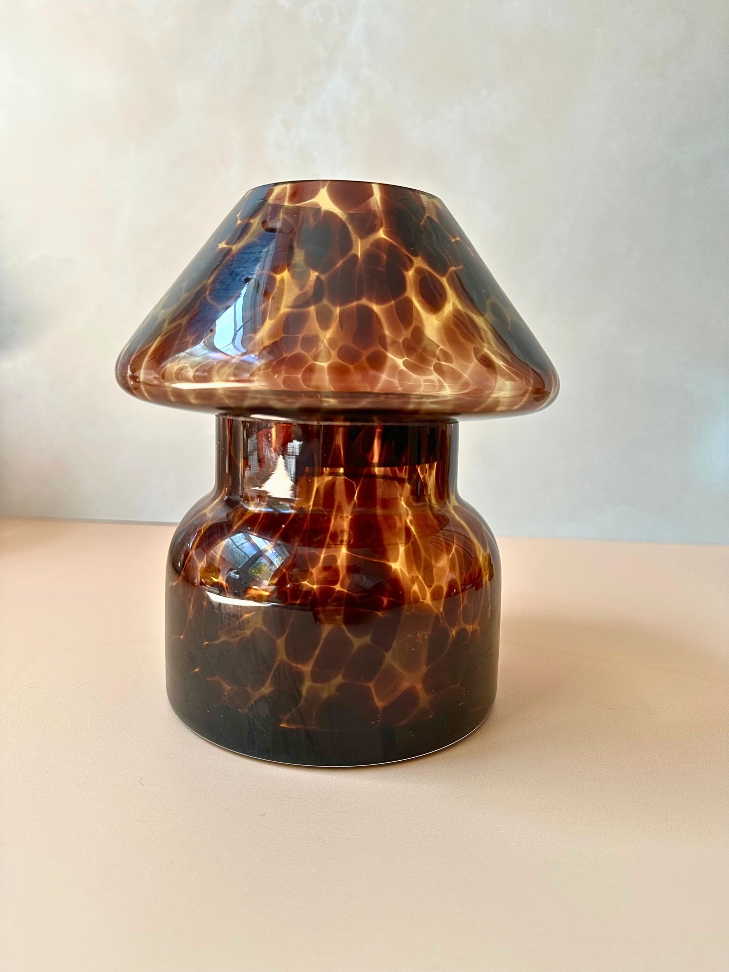 Tortoiseshell-patterned glass lamp on a plain background