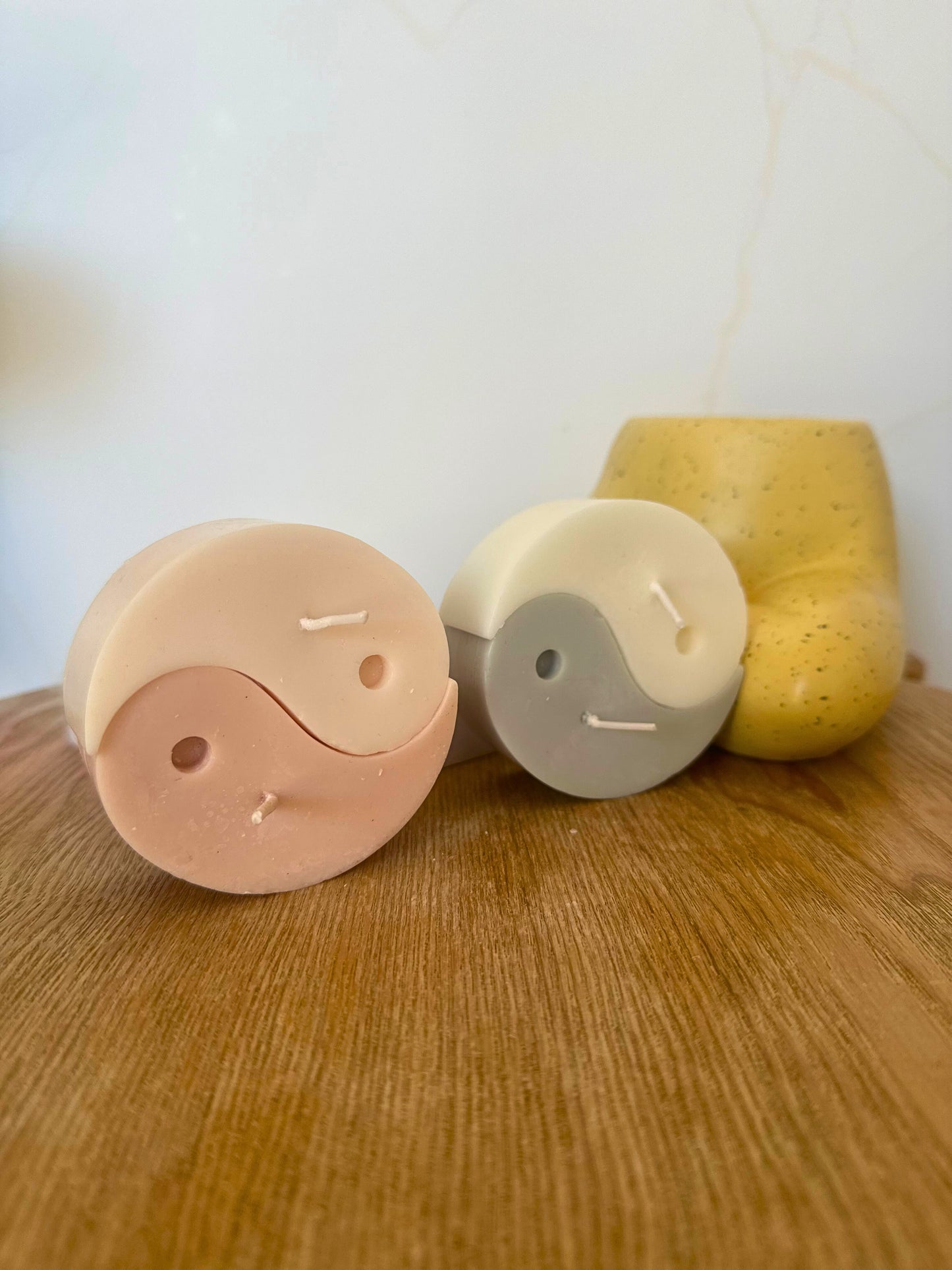 Three cylindrical containers with different colors on a wooden surface