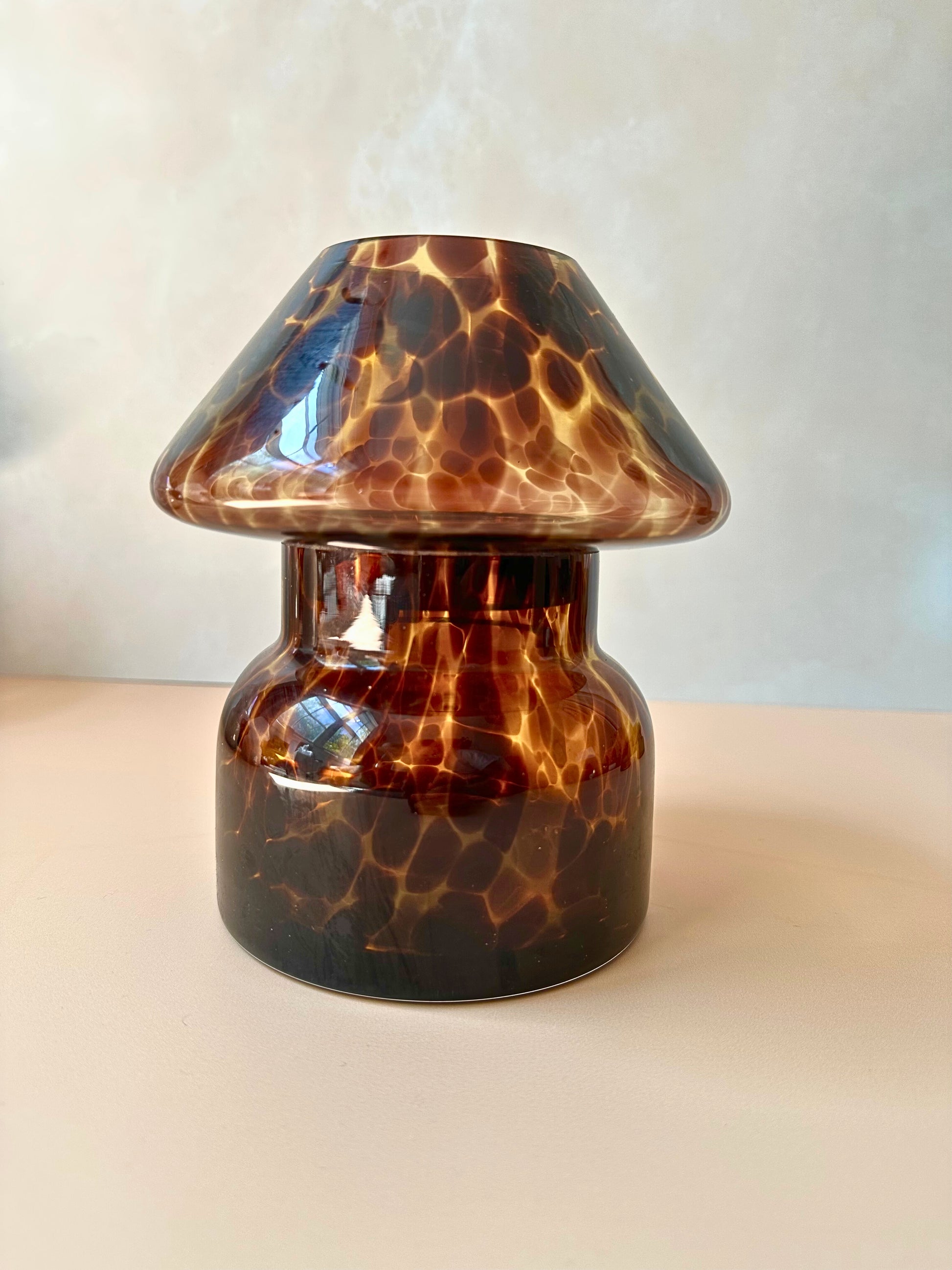 Tortoiseshell-patterned glass lamp on a plain background