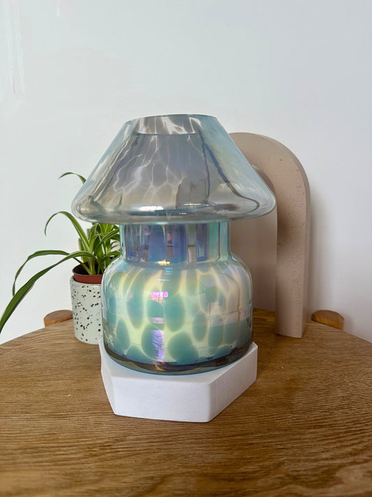 Decorative mushroom candle lamp with a glass shade on a wooden surface