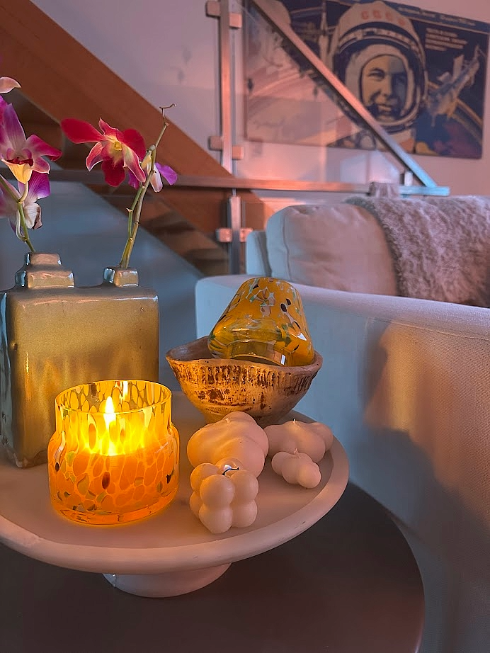 Decorative table setting with a lit Mini Mushroom Candle Lamp in Orange in a cozy room.