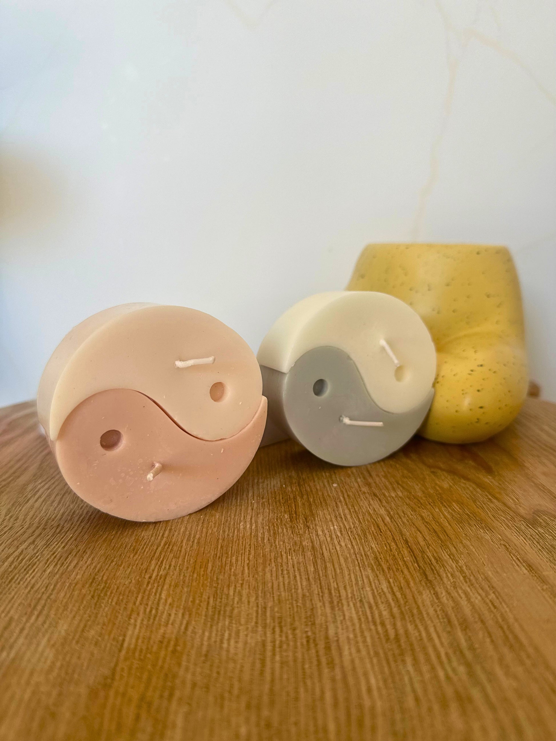 Three cylindrical containers with different colors on a wooden surface